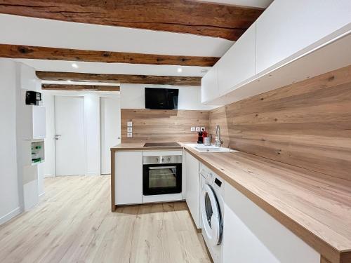 - une cuisine avec des appareils blancs et des murs en bois dans l'établissement T3 Halles Sainte-Claires Centre, à Grenoble