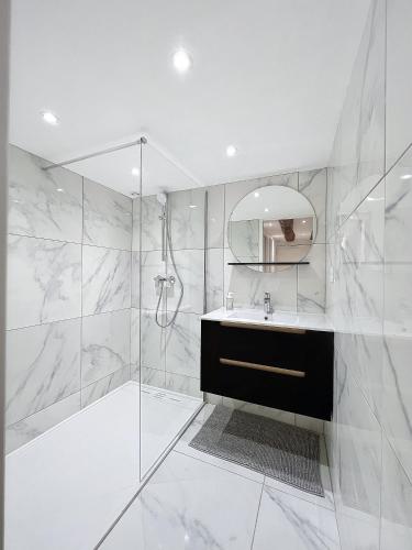 une salle de bain blanche avec un lavabo et une douche dans l'établissement T3 Halles Sainte-Claires Centre, à Grenoble