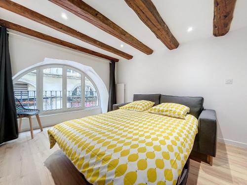 - une chambre avec un lit et une couette jaune et blanche dans l'établissement T3 Halles Sainte-Claires Centre, à Grenoble