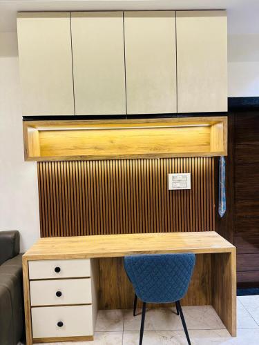 a desk with a blue chair and some cupboards at SkyPort Villa in Jodhpur