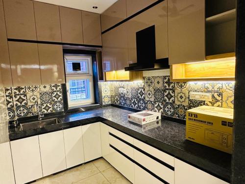 a kitchen with white cabinets and black counter tops at SkyPort Villa in Jodhpur