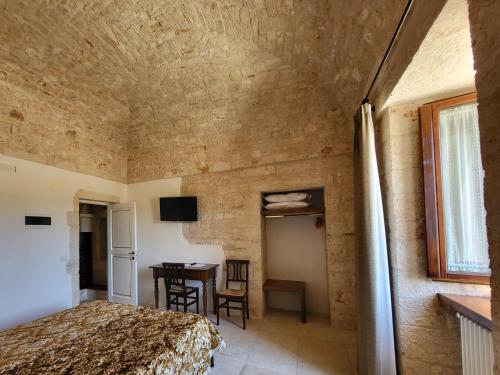 a bedroom with a bed and a table in a room at Masseria Santolomuto in Noci