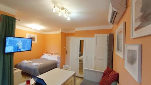 1 dormitorio con 1 cama y TV en la pared en Bonrila Sun Apartman en Zamárdi