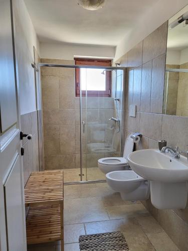 a bathroom with two toilets and a sink and a shower at Masseria Santolomuto in Noci