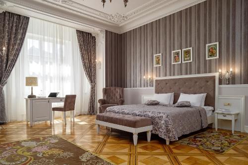 a bedroom with a bed and a desk and a chair at Modern Art Hotel in Lviv