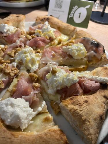 a pizza sitting on top of a white plate at B&B Del Centro e SPA in Partinico