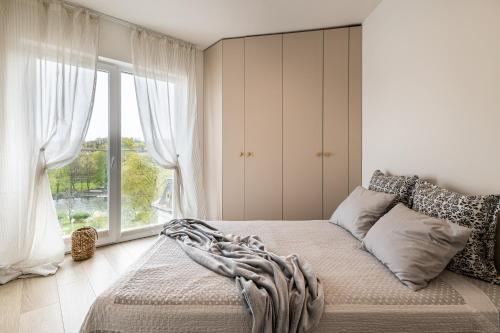 um quarto com uma cama e uma grande janela em 2HomeRent Apartamenty Urocza 10 em Bydgoszcz