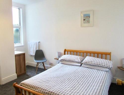 a bedroom with a bed and a desk and a chair at Westward B&B in Newquay