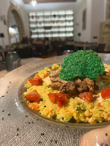 a plate of food with meat and vegetables on a table at B&B Del Centro e SPA in Partinico