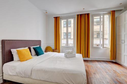 1 dormitorio con 1 cama grande y 2 ventanas en 101- Beautiful apartment near champs elysees en París