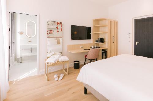 a bedroom with a bed and a desk with a computer at Hôtel Majestic in Bordeaux