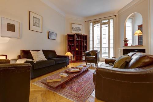a living room with two couches and a table at The Seine & Pont de l'Alma - CityApartmentStay in Paris