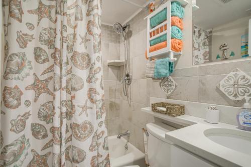 een badkamer met een douchegordijn, een toilet en een wastafel bij Wildwood Crest Condo with Pool and Beach Access! in Wildwood Crest