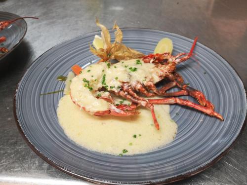 a blue plate with a lobster on top of mashed potatoes at Logis - Hotel Restaurant La Sapinière in Wisques