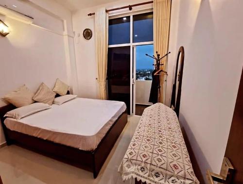 ein Schlafzimmer mit einem Bett und einem großen Fenster in der Unterkunft Pristine residence in Dehiwala
