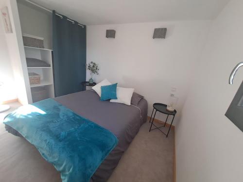 een slaapkamer met een bed met een blauwe deken erop bij Les glycines in Salles-la-Source