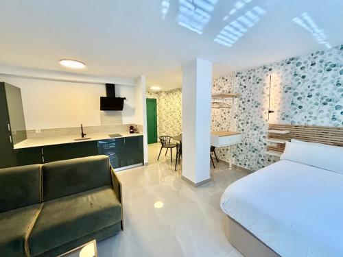 1 dormitorio con cama, sofá y cocina en Gulliver Suites Valencia, en Valencia