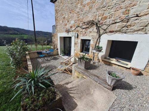 a stone building with a tv and some plants at Les glycines in Salles-la-Source