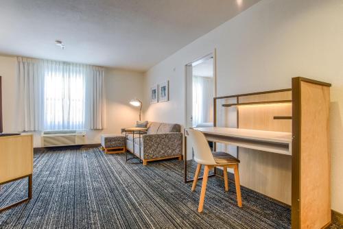 a hotel room with a bed and a desk at TownePlace Suites Mobile in Mobile
