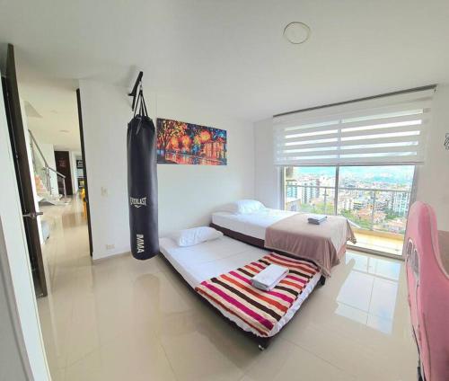 een slaapkamer met 2 bedden en een paddleboard bij Exclusivo penthose in Ibagué