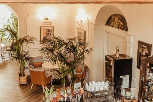 a living room with potted plants and a table at Hotel Willa Starosty in Międzyrzecz
