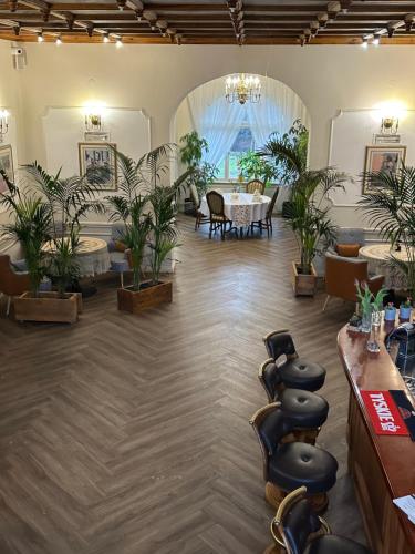 a room with potted plants and a table and chairs at Hotel Willa Starosty in Międzyrzecz