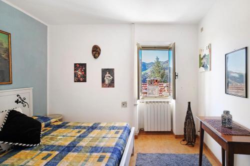 1 dormitorio con cama, escritorio y ventana en House of silence en Badalucco