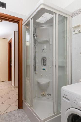 a bathroom with a toilet in a glass enclosure at ArtStay Exclusive Apt Linate, Parking, Terrace AC in Pioltello