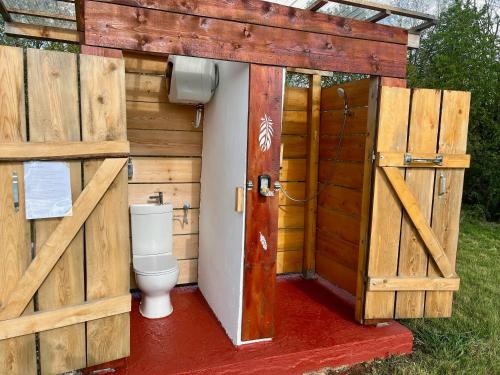 a toilet in a wooden shed with a door at Romantic Wildlife Tipi Teepee Tomnatic Bihor Romania Apuseni in Tomnatic