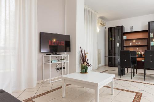 a living room with a white table and a tv at Spacious Exclusive Apartment in Pioltello