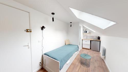 een slaapkamer met een bed in een witte kamer bij Immeuble COTY Jacuzzi studios et chambres in Le Havre