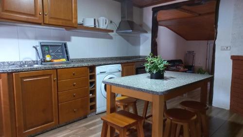a kitchen with a counter and a table with stools at Casa do Quitaranda - Gerês in Vieira do Minho
