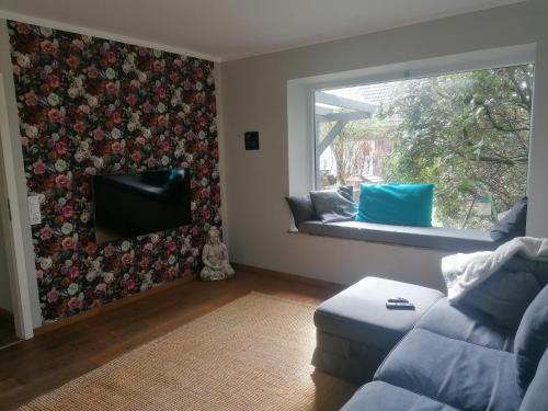 uma sala de estar com um sofá e uma janela em Haus Alma 1 em Wardenburg