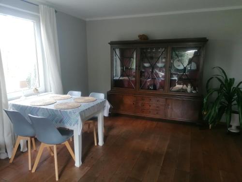 uma sala de jantar com mesa e cadeiras e um armário em Haus Alma 1 em Wardenburg