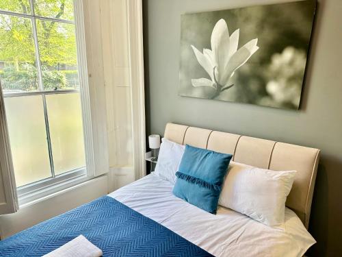 a bed with blue and white pillows in a bedroom at Harrington Apartments in Central London in London