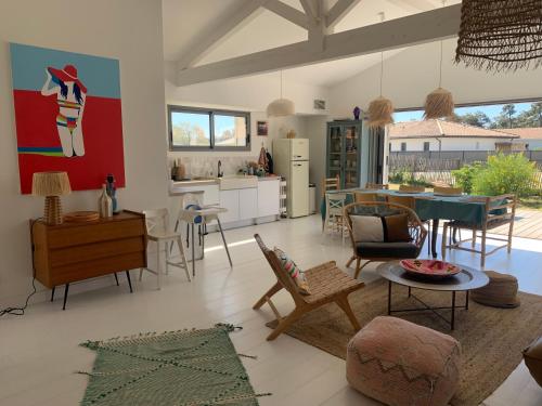 un salon avec une cuisine et une salle à manger dans l'établissement Maison de plage Montalivet, à Vensac