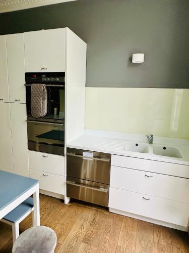 a kitchen with white cabinets and a stove at Harrington Apartments in Central London in London