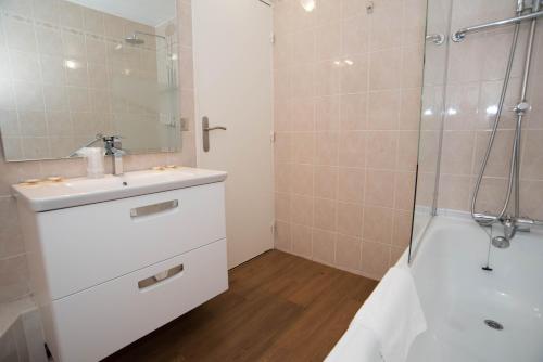 La salle de bains est pourvue d'un lavabo et d'une douche. dans l'établissement Hotel Novel Restaurant La Mamma, à Annecy