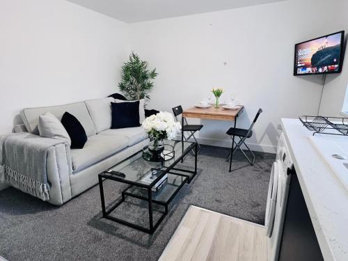 a living room with a couch and a table at Luxury 2-Bed Apartment Lindley Huddersfield in Huddersfield