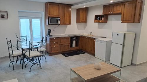 une cuisine avec une table, des chaises et un réfrigérateur dans l'établissement Appartement Arago, à Roanne