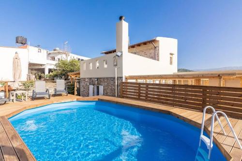 a swimming pool on a deck with a house at Traditional House with Private Pool in Rethymno
