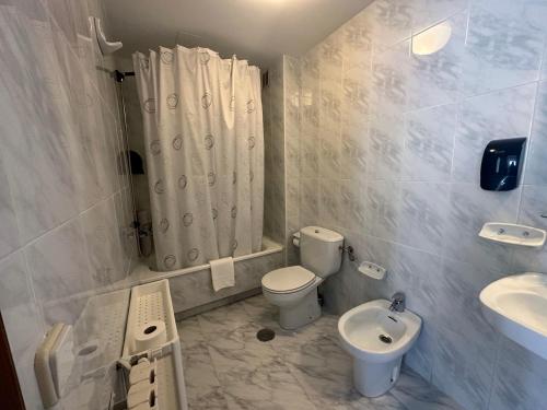 a bathroom with a toilet and a sink and a shower at Hotel Florida Mar in Sanxenxo