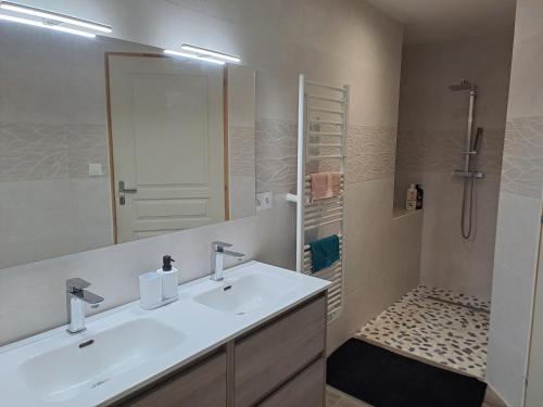 biała łazienka z umywalką i prysznicem w obiekcie Agréable maison climatisé w mieście Le Soler