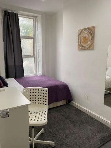 a bedroom with a purple bed and a window at LORD MERIT GUEST HOUSE KING'S CROSS GRAYS INN ROAD in London