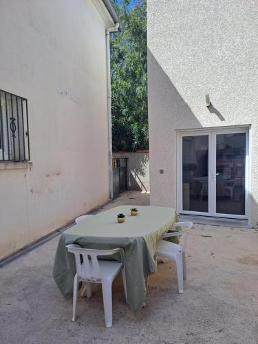einen Tisch und zwei Stühle vor einem Gebäude in der Unterkunft Agréable maison climatisé in Le Soler