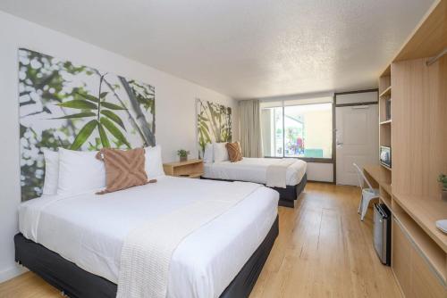 Habitación de hotel con 2 camas y TV en Upstay - Modern Suite w Pool - Mins From Disney, en Kissimmee