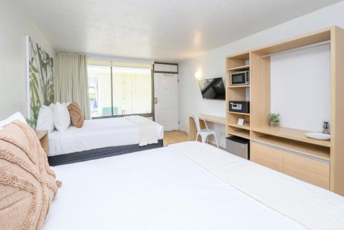 Cette chambre comprend deux lits et un bureau. dans l'établissement Upstay - Modern Suite w Pool - Mins From Disney, à Kissimmee