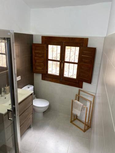 a bathroom with a toilet and a sink and a window at Captivating 3-Bed Villa in Antas in Antas