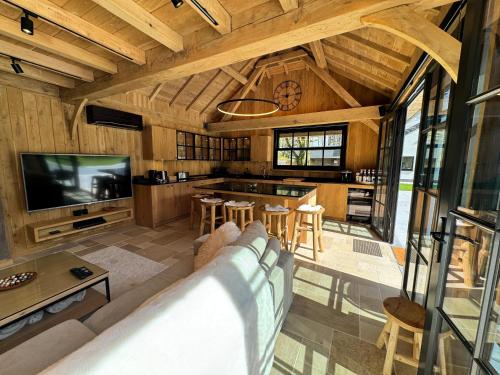 a living room with a couch and a tv at Magnifique chalet en bois avec piscine et jacuzzi in Court-Saint-Étienne