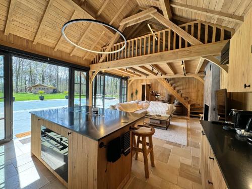 uma cozinha com uma grande ilha numa casa em Magnifique chalet en bois avec piscine et jacuzzi em Court-Saint-Étienne